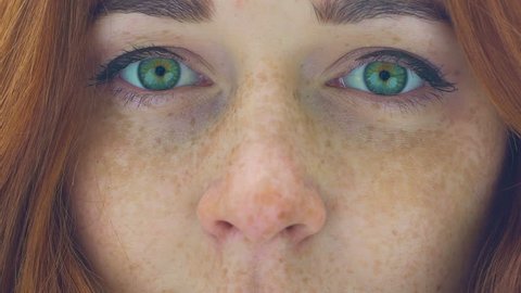 Beautiful woman face with freckles red hair green eyes zoom in extreme close up