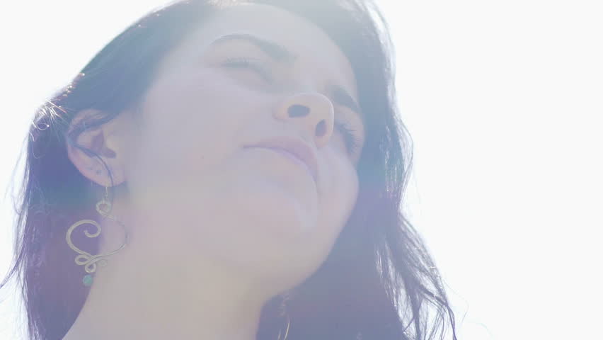 Pretty woman in sun light enjoys oneness with nature, beautiful brunette happy