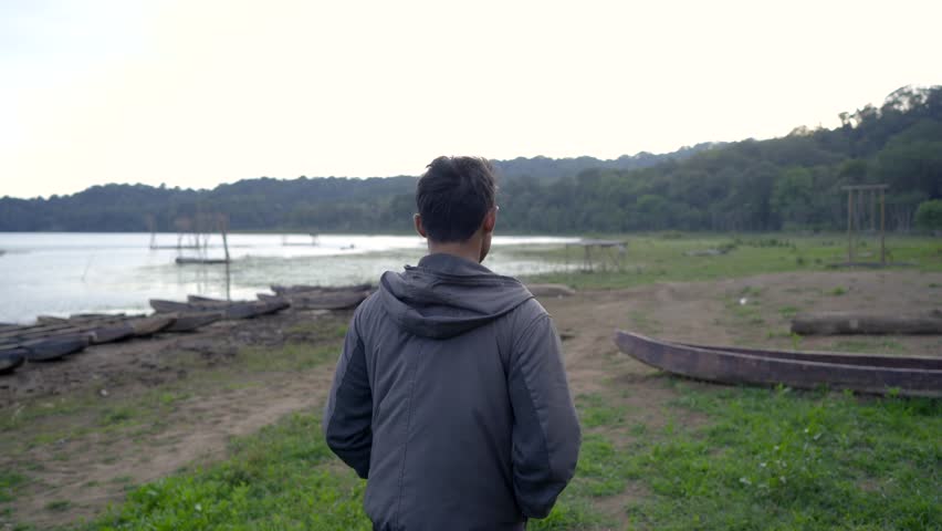portrait of a man walking on a lake side in countryside