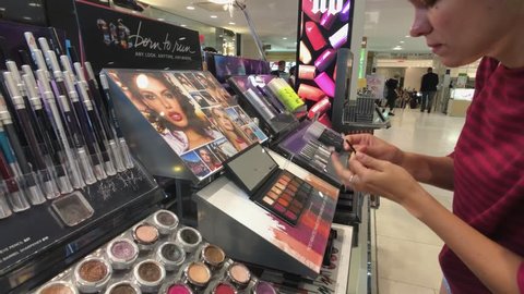 New York, USA - September 6, 2018: Woman testing makeup in Macys store
