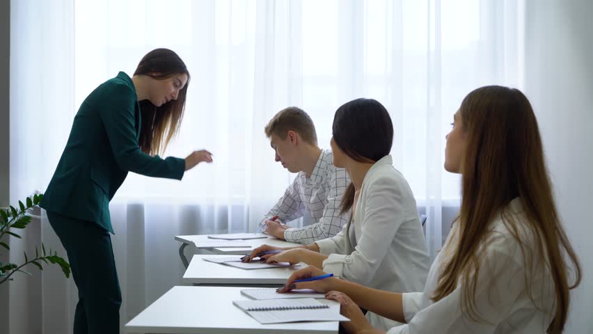 Young caucasian teacher chek and control college students knowledge and skills in classroom. practice, learning, education, knowledge, development, growth concept | Shutterstock HD Video #1018473283