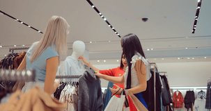 Girl chooses clothes in the store with her friends and goes to the cashier