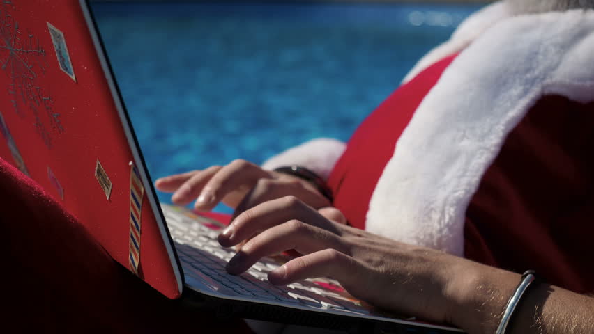 Santa Claus hands typing at laptop keyboard connection to wifi and working on the holiday near with swimming pool. Concept of freelance and freedom in the job. summertime and tropical xmas in resort Royalty-Free Stock Footage #1018481233