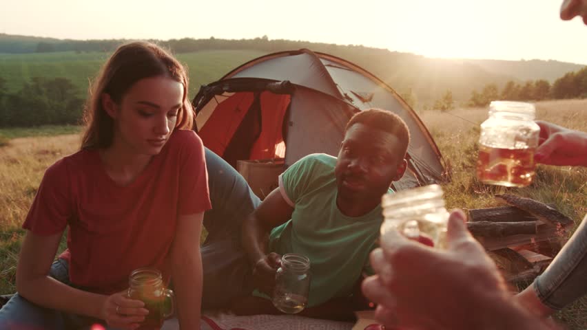 Close up view of young people having camping party outdoors, cheering up with beer. Celebration time, going crazy, hanging out. Party concept, hiking, camping. Little adventure Royalty-Free Stock Footage #1018481548