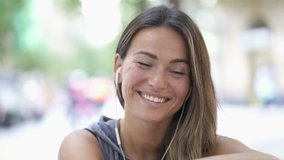 Relaxed young woman outdoors with earbuds