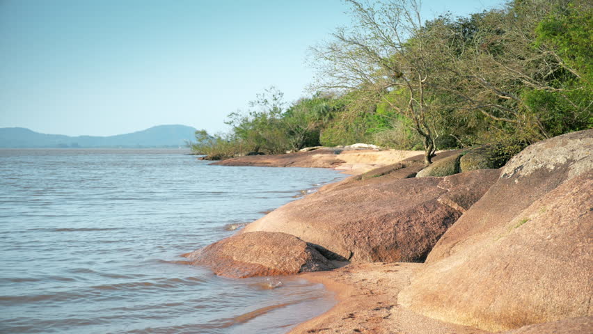 River Shore Landscape. Beautiful shot of a river shore with vegetation and big rocks