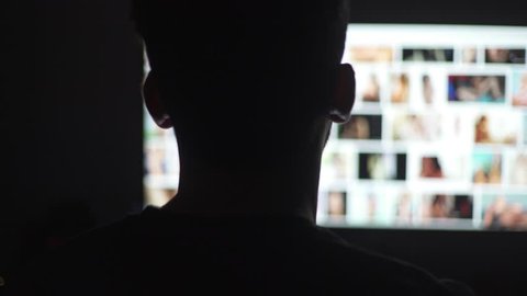 Young man watching naked women in the computer screen