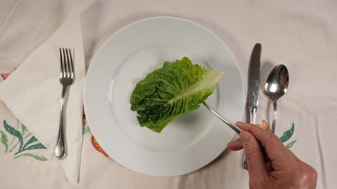 Serving a single leaf of romain salad at the dinner table.