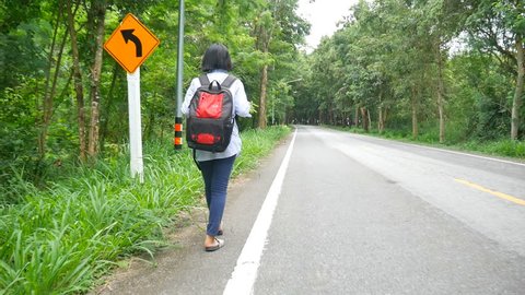 Young Asian traveler walking alone on the road