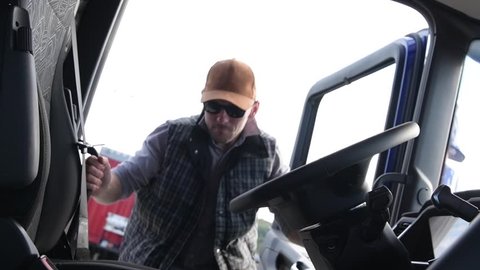 October 15, 2018. Krakow, Lesser Poland. Caucasian Truck Driver in His 30s Getting into the Semi Cabin. European Transportation. Closeup Slow Motion Video.