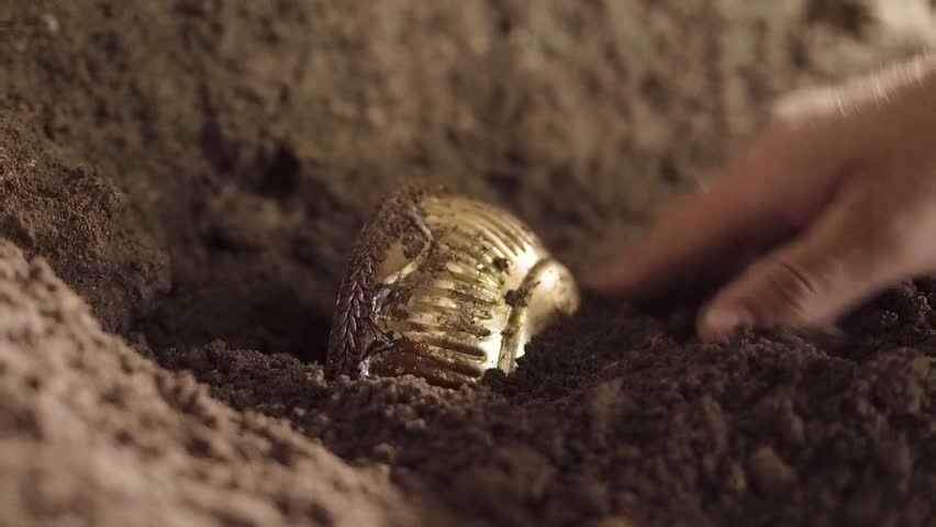 A man like Jesus Christ is digging a hole in the dungeon, a man is searching for a precious treasure, a man in a white robe is digging the earth with a stick and finds gold, Jesus hides the holy grail | Shutterstock HD Video #1018537807