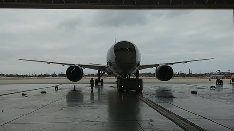 787 aircraft Being towed into a hangar.