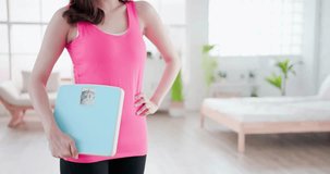 sport woman hold weight scale at home