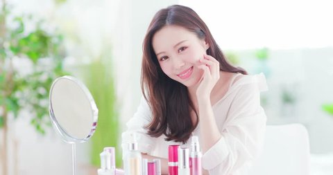 Beauty woman smiles to you with skin care products at home
