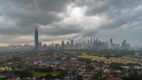 Time lapse: Dramatic afternoon view of the Kuala Lumpur skyline with dark and fast cloud during monsoon season in Kuala Lumpur, Malaysia. Tilt down motion timelapse. Prores 4k