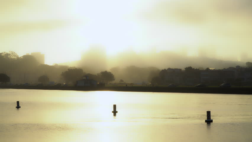 Sun rise over Russian Hill in San Francisco.  The bay in the foreground.  Fort Mason on the left.  Clearing fog and sun rays.