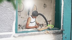 Teenage boy repairing the wheel on a bicycle