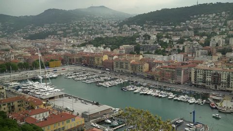 Port of French city of Nice with its yachts and cars. Concept of luxury lifestyle and travel. Locked down real time establishing shot