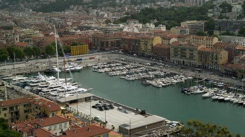 View of port of luxury French resort Nice. Yachts in the harbour, cars are driving by. Locked down real time establishing shot