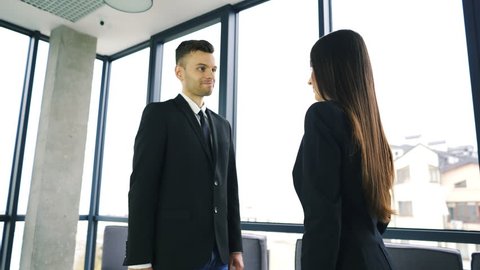 4K. Office meeting. Two business partner, man and woman, with pleasure shake hands and smile.