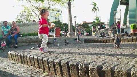 San Jose, San Jose / Costa Rica - 03 20 2017: Young boy feeding pigeons in San Jose streets with his dad