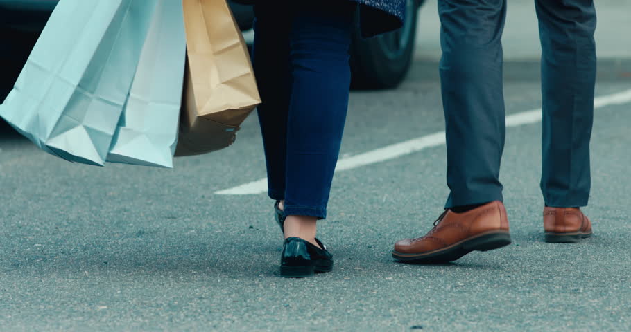 Young adult Caucasian couple or family walking towards their brand new car after shopping. 4K UHD 60 FPS SLOW MOTION