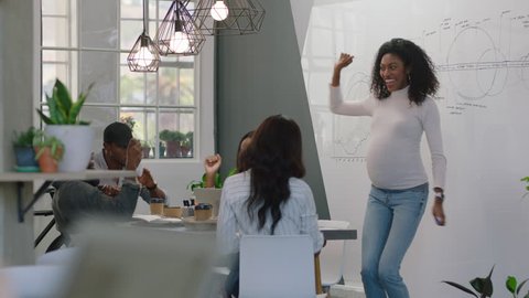 successful pregnant business woman celebrating success african american team leader dancing funny excited colleagues clapping enjoying corporate victory in boardroom presentation meeting
