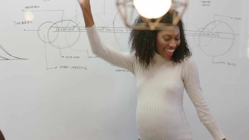 Successful pregnant business woman celebrating success african american team leader dancing funny excited colleagues clapping enjoying corporate victory in boardroom presentation meeting