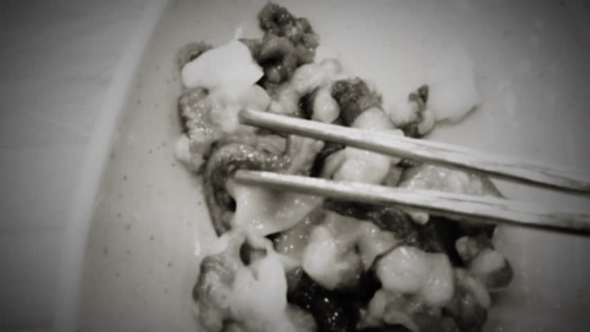 old vintage cinematic look  of 8mm film or a simulation of vintage film  or 8mm amateur film of a fresh chopped live squid with sesame oil and salt or Sannakji hoe, Raw live baby octopus dish of Korea