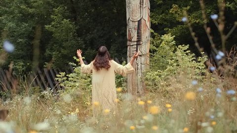 A man in the image of an ancient Slav walks through the old Russian city, a man resembling Jesus walks through the field and near the cross, a bearded long-haired actor in a cape plays historical role
