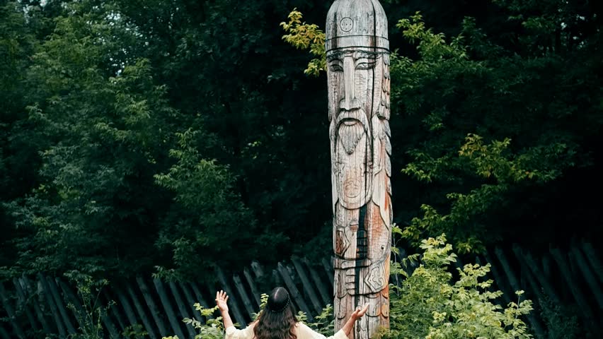 A man in the image of an ancient Slav walks through the old Russian city, a man resembling Jesus walks through the field and near the cross, a bearded long-haired actor 