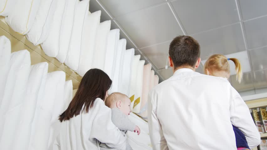 A family on shopping. A married couple choose the bedding