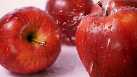 water drop splashing on fresh red apples on white background .Natural Fresh Organic Healthy Fruit concept , slow motion scene