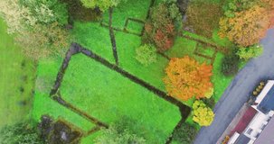 Aerial footage of foliage in small Estonian town at sunset. Autumn aerial flyover of scenic sunset in town.