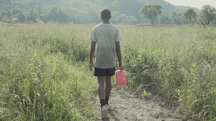 An African boy walks to collect water.