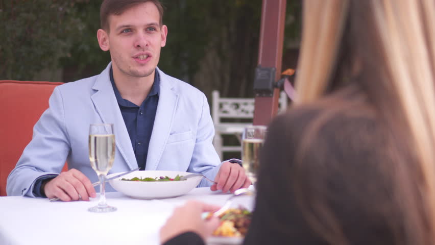 Young couple dating at outdoor restaurant