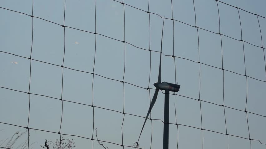 Slow Motion. Wind Turbine operating behind barriers.