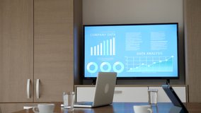 Close up of empty business meeting room with big screen TV displaying company data and animated charts. Dolly slider 4K footage