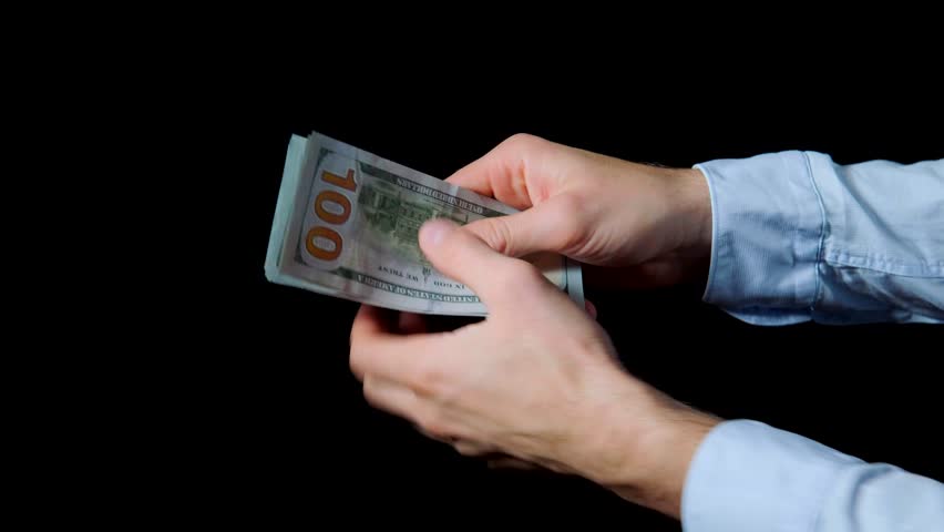 Counting and handing money, man's hands with blue shirt carefully counting hundred dollar notes and showing them off and bashing over palm. Isolated close up on black background. Royalty-Free Stock Footage #1018693591