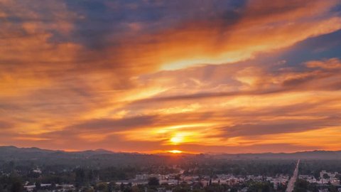 Aerial hyperlapse of fiery red sunset over San Fernando Valley cityscape. Los Angeles, California. 4K UHD. Stock Video