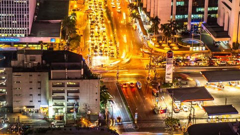 METRO MANILA, PHILIPPINES - CIRCA MARCH 2018: Time-lapse view on the traffic of a busy crossroad in Makati at night circa March 2018 in Metro Manila, Philippines.

