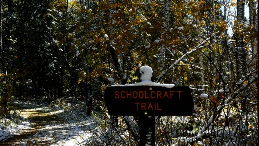 Man hiking on Schoolcraft Trail in Lake Itasca State Park, Minnesota on sunny morning after early autumn snowfall