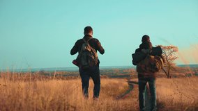 people tourists lifestyle travel in nature the autumn go on the road path adventure . slow motion video. two hiker with outdoor backpacks hiking. tourist concept the travel man tourism