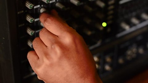 Hands turning knobs to an electric amplifier.