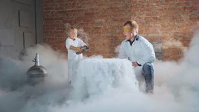 Male scientist with little schoolgirl conducts a chemical experiment with boiling water and liquid nitrogen. A lot of white smoke and positive emotions from the reaction. Chemical education concept - Powered by Shutterstock - Get 15% off with code: PIKWIZARD15