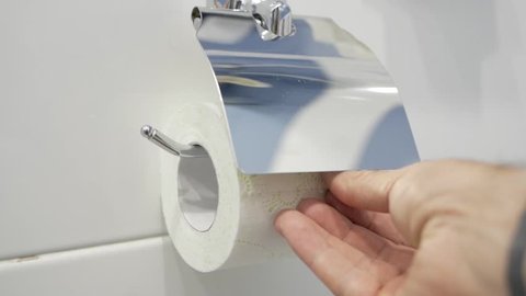 Male hand tear off toilet paper