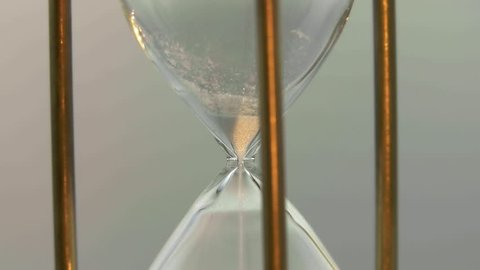 Deadline. Time is over. Macro shot of sand in the hourglass.