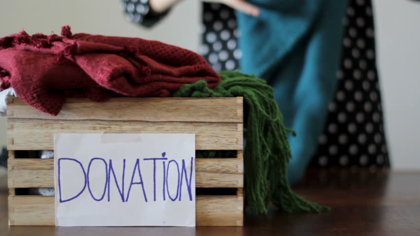 Woman folds clothes and puts inside a box for donation Royalty-Free Stock Footage #1018752043