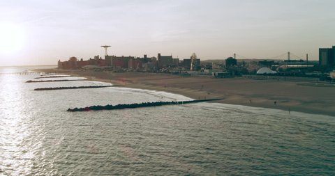 Aerial view of the shoreline of Coney Island at dusk, New York City, with soft natural lighting. Wide shot on 4k RED camera