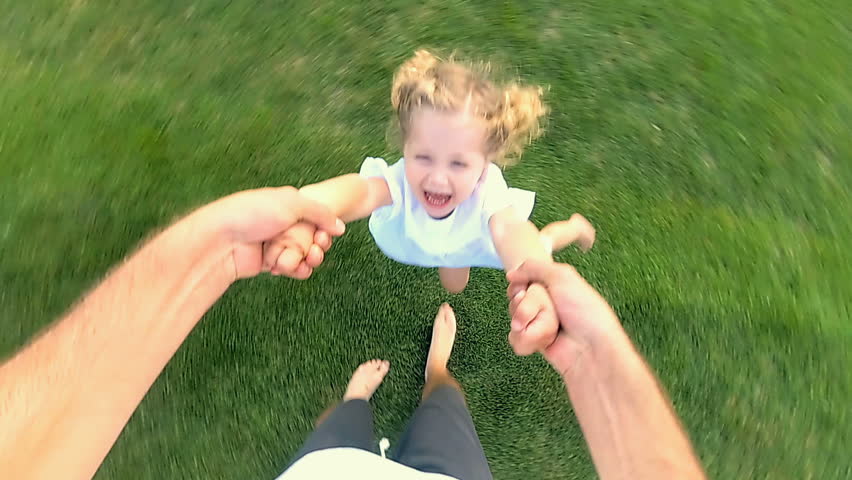 Father holding hands of little cute daughter. They having fun outdoors and whirling arounf themselfes. | Shutterstock HD Video #1018758604